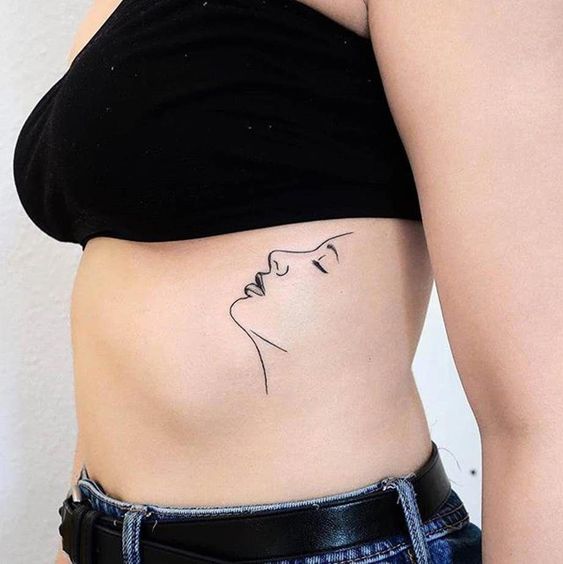 Women-face-on-rib-tattoo