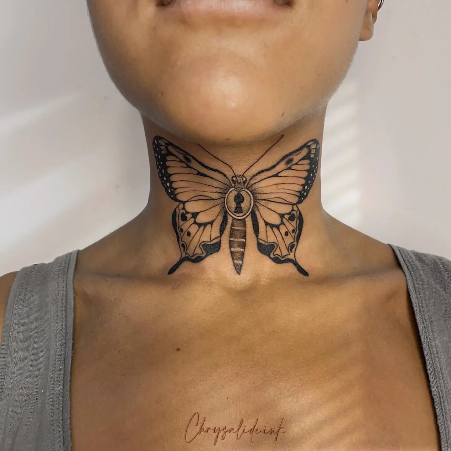 Big Bold Blackwork Butterfly Tattoo on Woman’s Neck