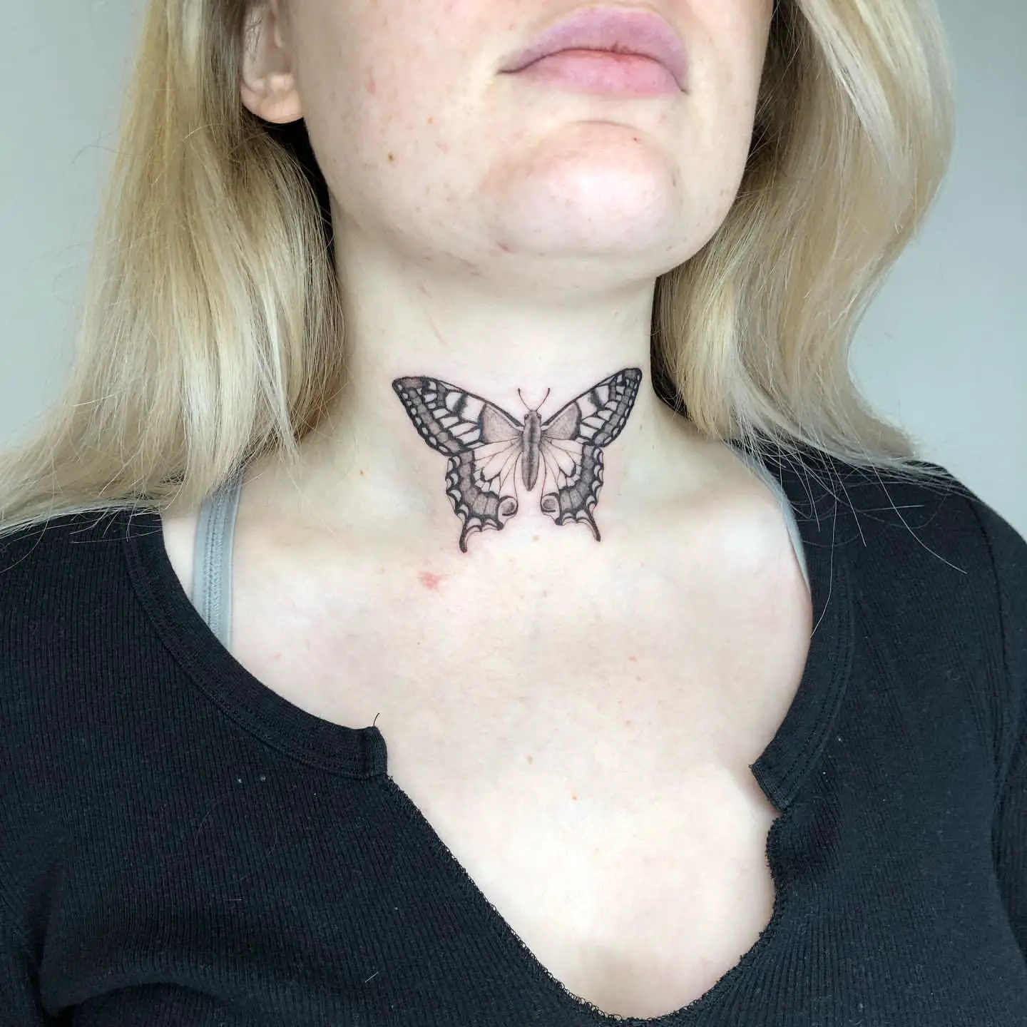 Realistic Black and Gray Butterfly Tattoo on Front of Neck